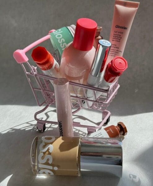 a mini shopping cart of glossier products 