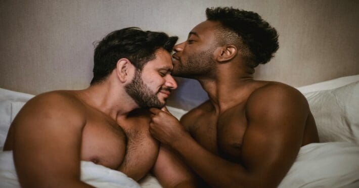 Gay interracial couple laying in bed