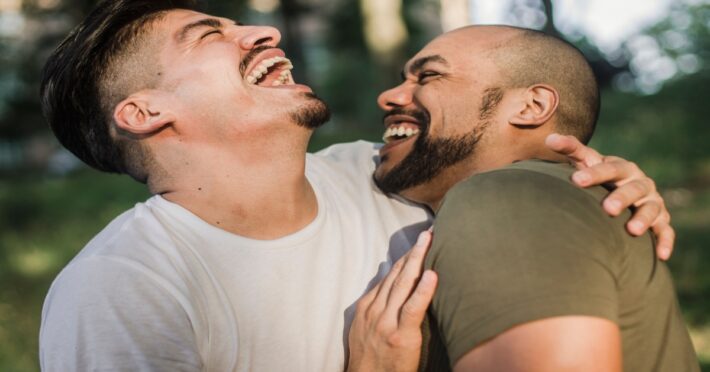 Two men laughing from a corny pickup lines