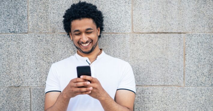 man smiling at their phone