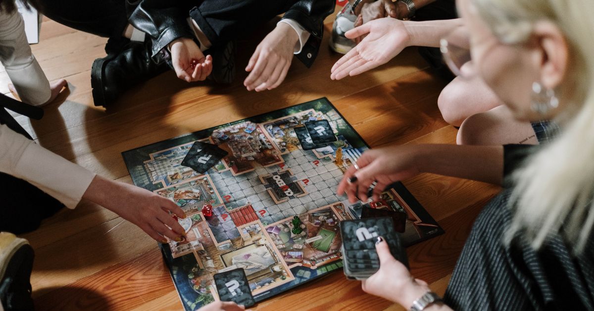 A group seated playing a board game, centered in the photo