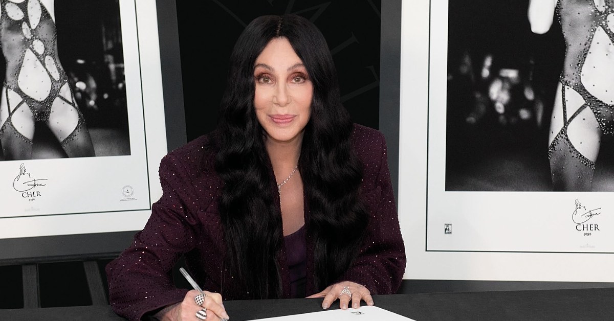 Cher signs autographs at event.