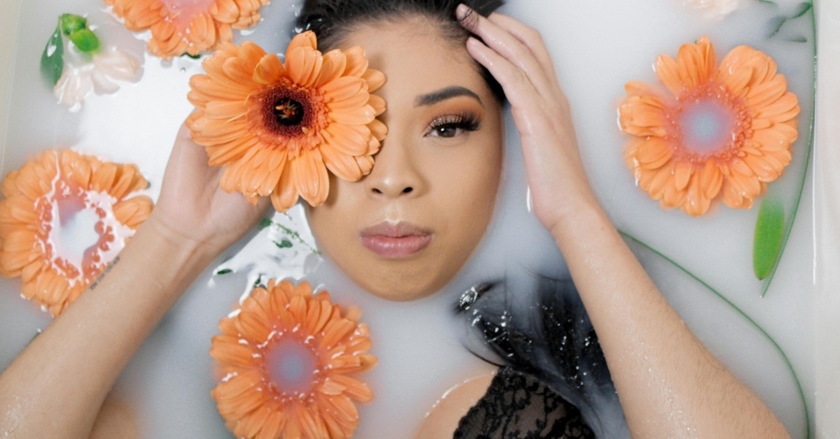 A woman in a tub with orange sunflowers